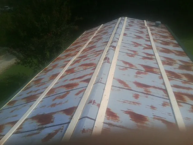 Rusted metal roof panels with new wood purlins before replacement — Storm Damage Roof Repair in Battleboro by Roofing Brothers